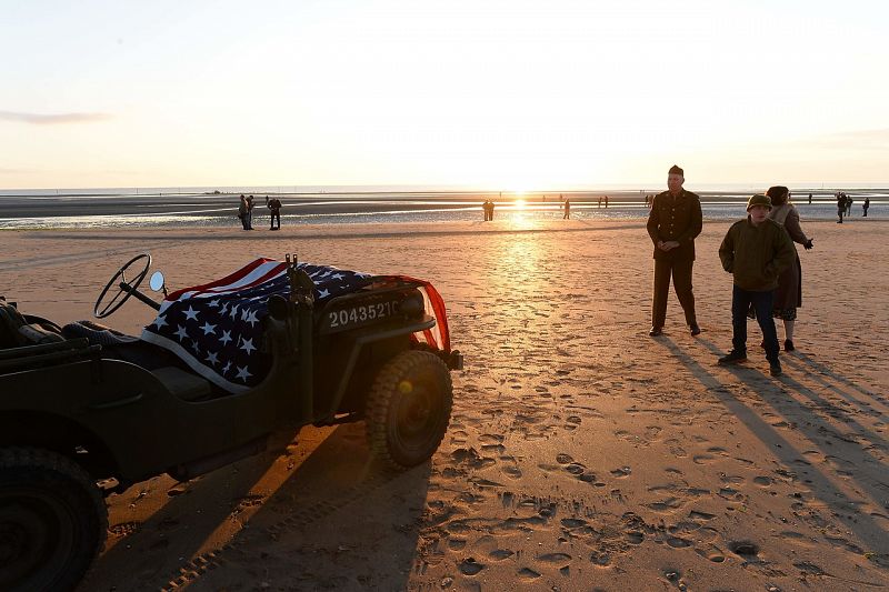 Entusiastas de la historia de la II Guerra Mundial, vestidos de época y con un jeep, en la playa de Utah, en Sainte-Marie-du-Mont, uno de los escenarios del desembarco.