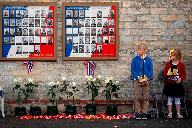 Niños franceses sostienen antorchas como homenaje a los miembros de la resistencia en la prisión de Caen, en Normandía.