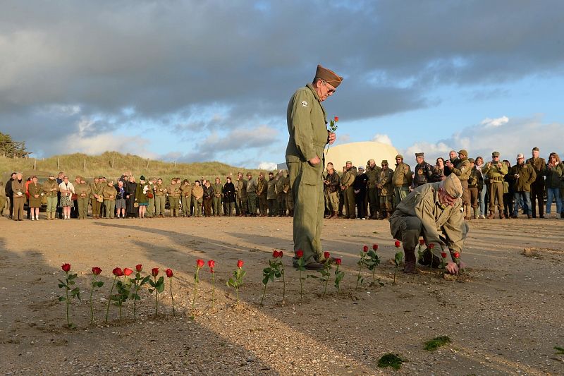 Un grupo de franceses aficionados a la II Guerra Mundial, que se hacen llamar Overlord 76, plantan rosas en la playa de Utah.