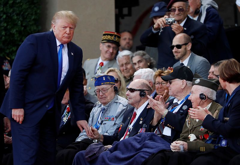 El presidente norteamericano Donald Trump saluda a los veteranos de la Segunda Guerra Mundial que participan en la ceremonia celebrada en el cementerio de Colleville-sur-Mer.