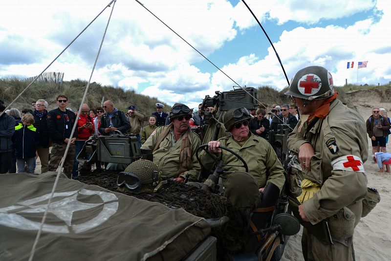 Unos apasionados de la Segunda Guerra Mundial de origen belga vestidos como soldados y con jeeps en la playa de Utah, en Sainte-Marie-du-Mont.