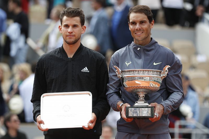 Rafa Nadal y Dominic Thiem posan junto a sus trofeos de Roland Garros.