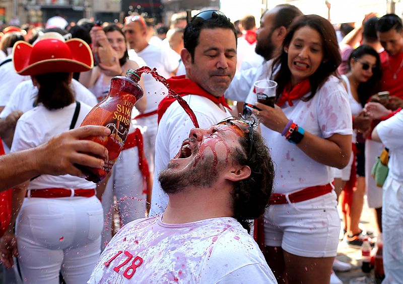 Un hombre bebe sangría antes del chupinazo