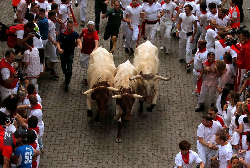 Los participantes corriendo delante de los toros de la ganadería del Puerto de San Lorenzo en el primer encierro de los Sanfermines 2019. 