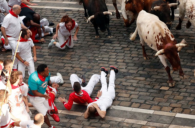 Una corredora de rodillas mientras se acerca un toro