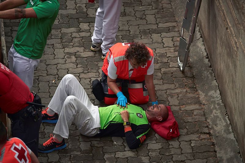 Un participante en el encierro recibe asistencia sanitaria