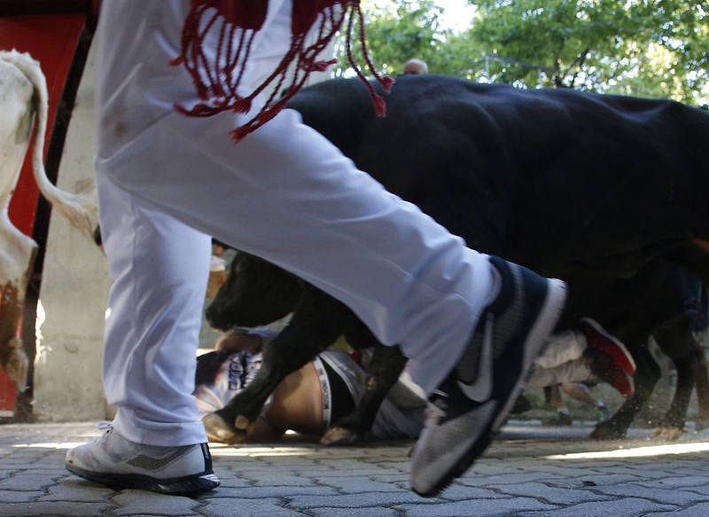 Un toro pisotea a un corredor