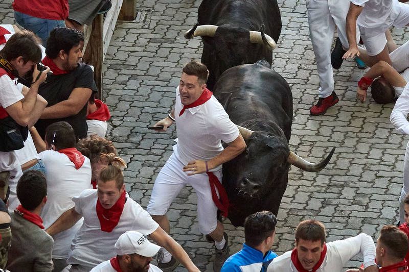 Un participante en el encierro delante de un toro