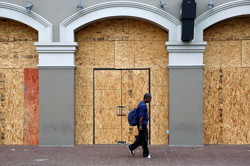 Un hombre camina junto a una tienda cerrada en Nueva Orleans