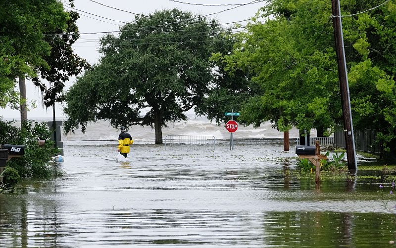 Un hombre camina por un área inundada en Mandeville, Luisiana