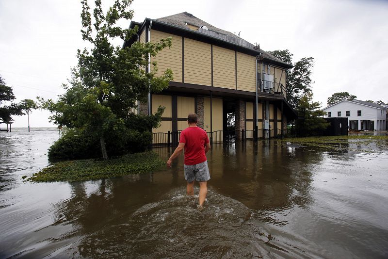 Shane Matter camina sobre una calle inundada hacia un restaurante cerca del lago Pontchartrain