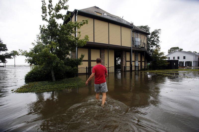 Shane Matter camina sobre una calle inundada hacia un restaurante cerca del lago Pontchartrain