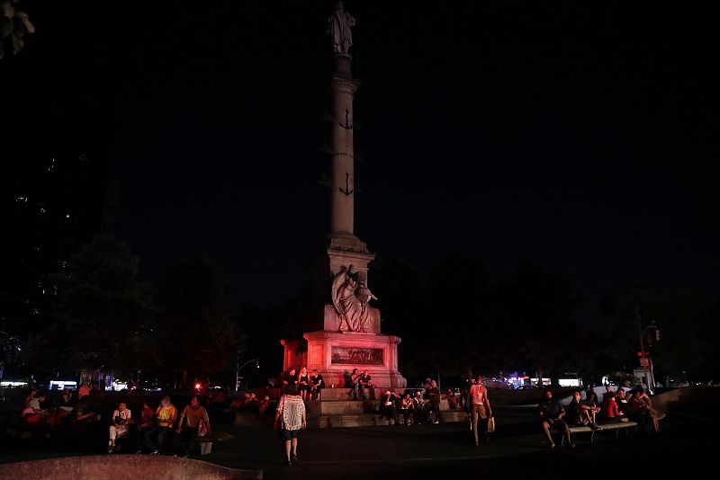 Ciudadanos esperando junto al Columbus Circle de Manhattan la restauración del servicio eléctrico.