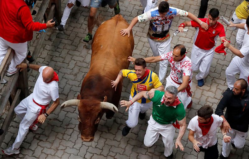 Los corredores participan en el octavo encierro de los Sanfermines 2019, protagonizado por los toros de la ganadería Miura.