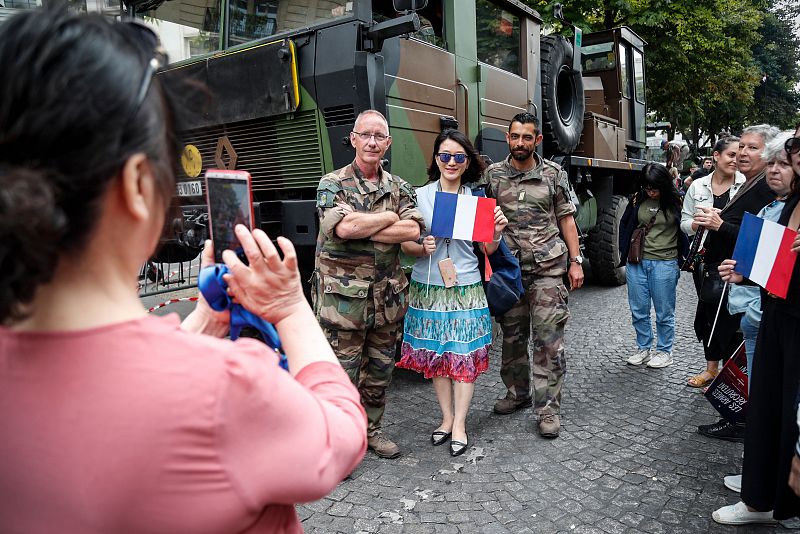 Soldados franceses posan con el público asistente al desfile