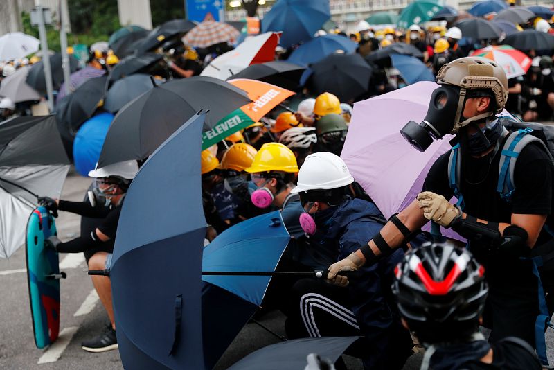 Los manifestantes se protegen con paraguas