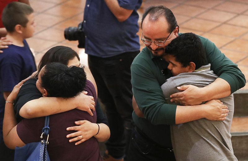 Un grupo de personas se abrazan durante la vigilia por el tiroteo.