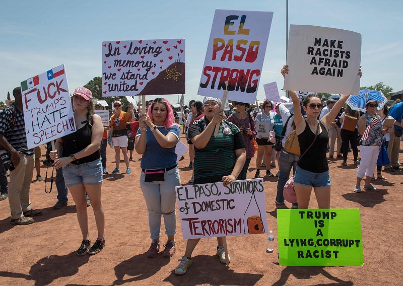 Varias mujeres sostienen distintas pancartas para recordar a Trump que no es bienvenido en El Paso