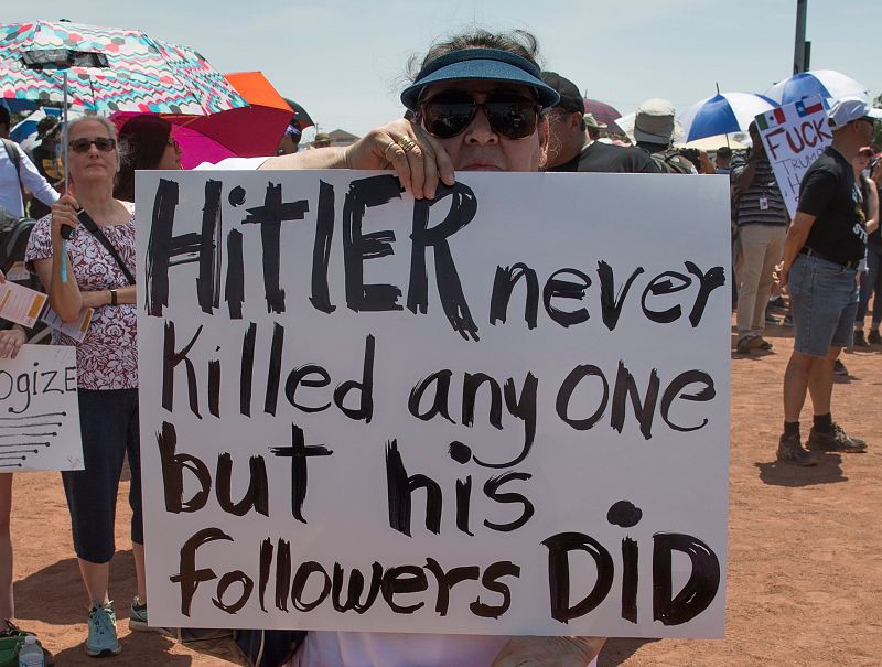 Una manifestante en El Paso sostiene una pancarta en la que se lee que "Hitler no mató a nadie, pero sus seguidores sí"