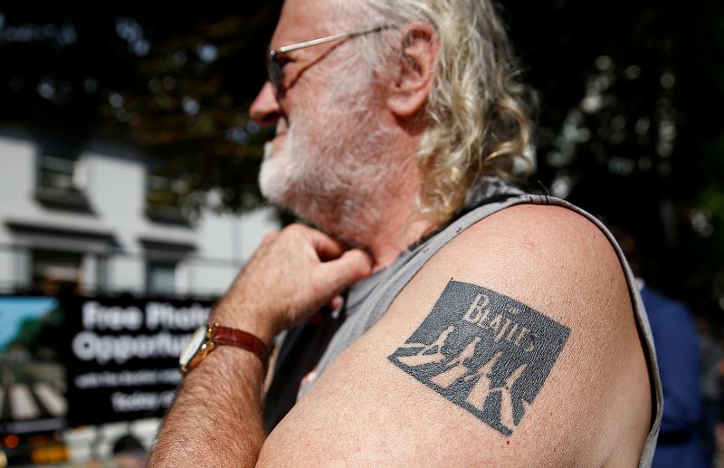 Un hombre con un tatuaje de The Beatles en su brazo celebra los 50 años de Abbey Road.