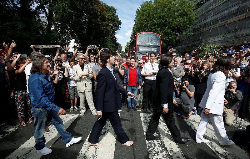 Un grupo de imitadores de The Beatles cruza el mítico paso de cebra de Abbey Road, de cuya imagen se cumple 50 años este jueves.