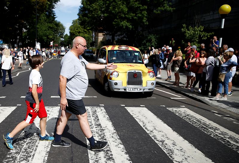 Un grupo de personas cruza por el paso de cebra de Abbey Road.