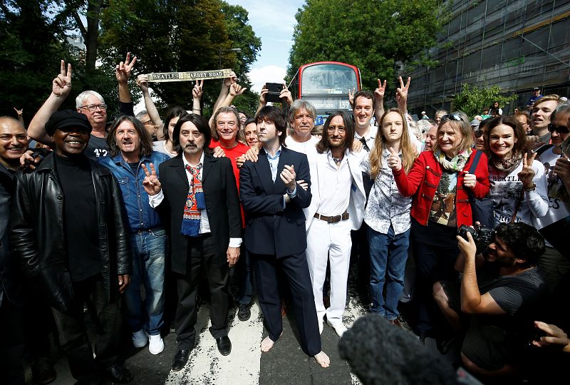 Miembros de la banda tributo 'Fab Gear' posan con fans de The Beatles en Abbey Road.