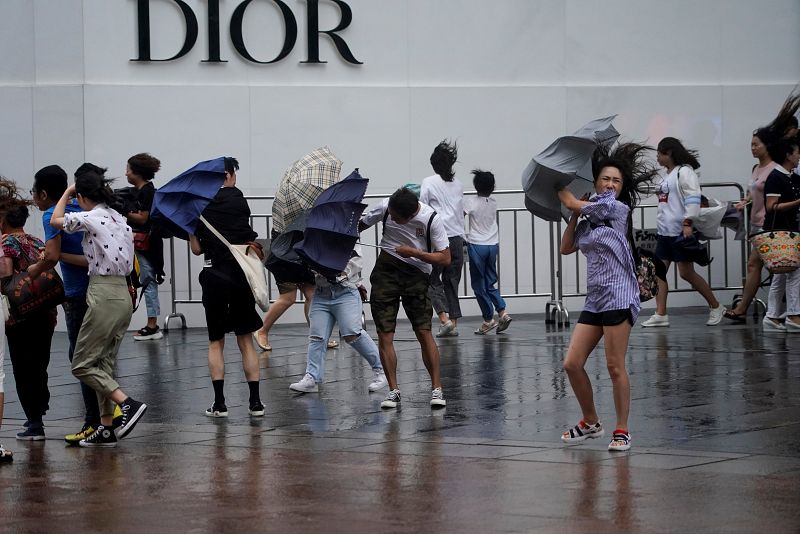 Numerosas personas caminan y realizan compras en Shangahi durante el tifón Lekima.