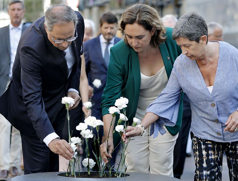 La alcaldesa de Barcelona, Ada Colau, acompañada por el presidente de la Generalitat, Quim Torra y de la delegada del Gobierno en Cataluña, Teresa Cunillera (d), depositan claveles blancos. 
