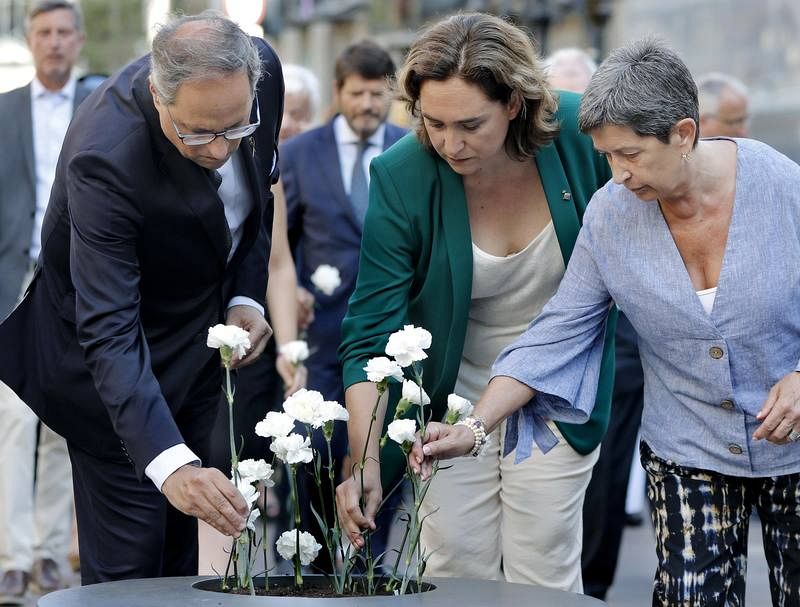La alcaldesa de Barcelona, Ada Colau, acompañada por el presidente de la Generalitat, Quim Torra y de la delegada del Gobierno en Cataluña, Teresa Cunillera (d), depositan claveles blancos. 