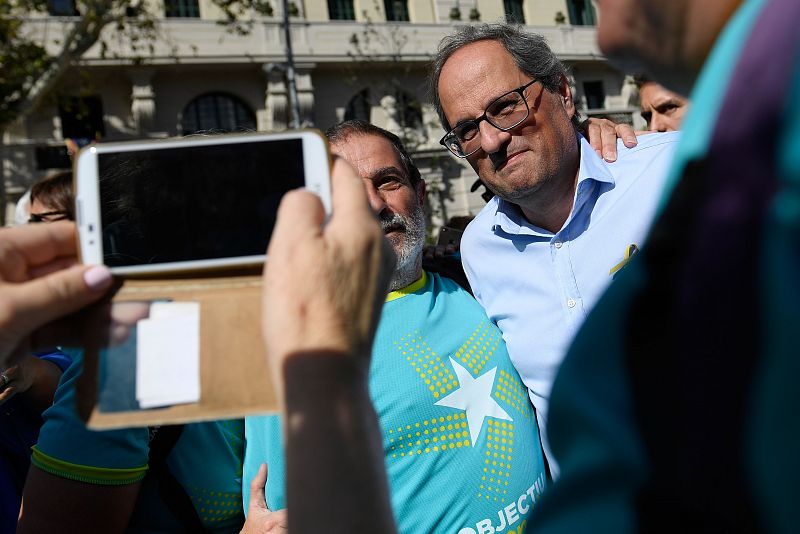 El presidente de la Generalitat de Cataluña, Quim Torra (d), posa para una foto junto a uno de los asistentes a la manifestación con motivo de la Diada. 