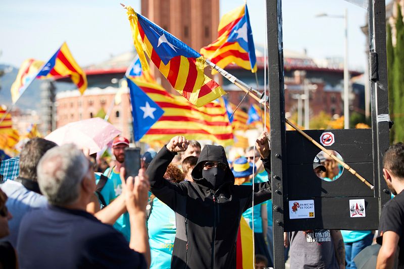 Un joven muestra una guillotina durante la manifestación independentista