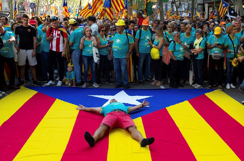 Un hombre se tumba sobre la estelada, durante la manifestación independentista organizada con motivo de la Diada.