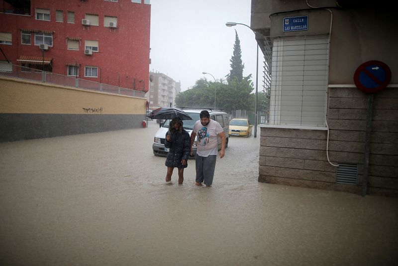 Gota fría: Unas personas atraviesan una calle inundada cercana al río Segura en el municipio de Orihuela. 