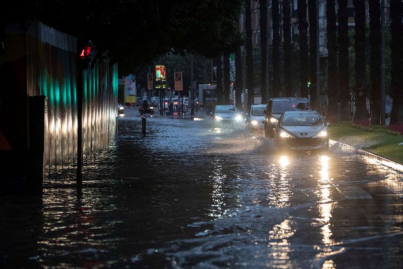 Gota fría en Murcia: Varios coches circulan en la mañana de este viernes por la calle Plano de San Francisco de Murcia, inundada