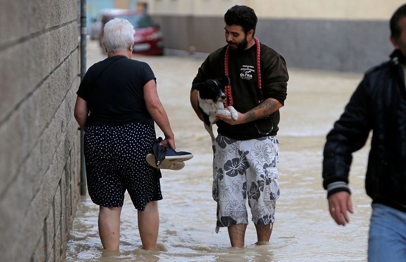 Gota fría: Varias personas caminan por la calle en Orihuela (Alicante), inundada por las lluvias torrenciales y la crecida del río Segura.