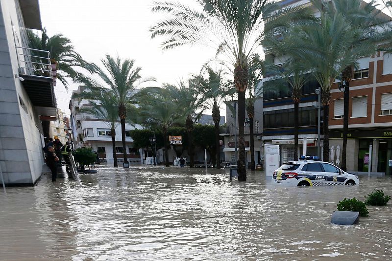 Un coche de Policía aparcado en una calle inundada de Dolores