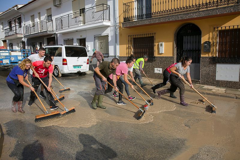 Vecinos de Villanueva del Trabuco, una de las zonas más afectadas por la gota fría en la provincia de Málaga, limpian las calles y retiran el barro tras la tromba de agua de la última noche