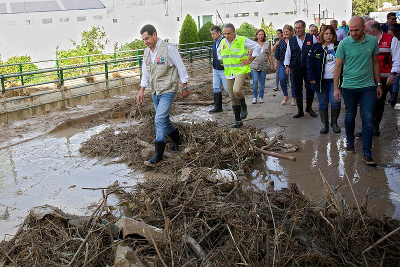 El presidente del Gobierno de Andalucía, Juanma Moreno, acompañado por el alcalde de Villanueva del Trabuco, José María García, entre otros, durante su visita a esta localidad andaluza, una de las zonas más afectadas por la gota fría