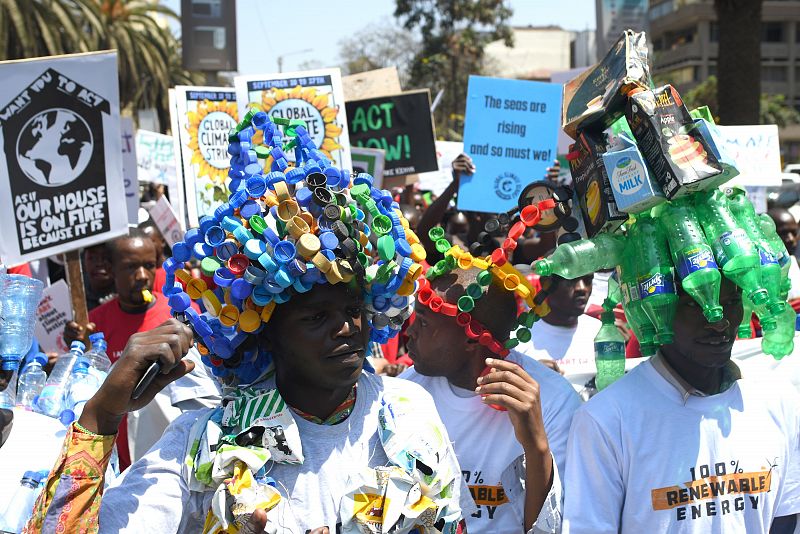 Dos manifestantes de Kenia llevan prendas elaboradas con bottelas de plástico, tapones y varios tetrabrik durante las protestas contra el cambio climático realizadas en el país.