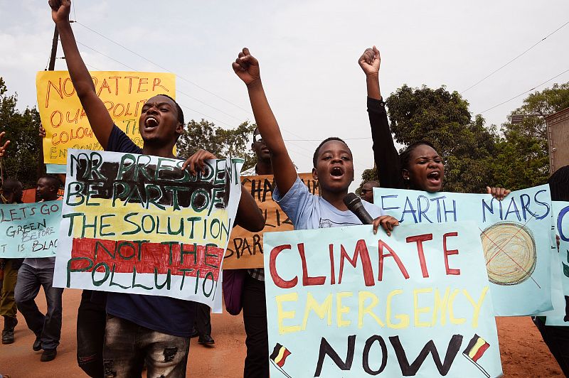 Jóvenes ugandeses elevan pancartas durante la protesta contra el cambio climático celebrada en Wakiso.