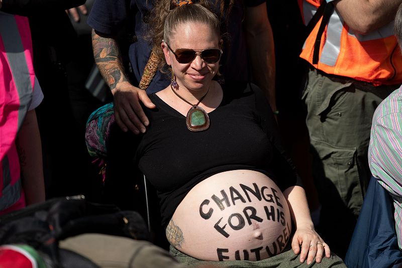 Una activista embarazada reivindica frenar el cambio climático para que asegurar el futuro de su hijo ante el Parlamento de Wellington, en Nueva Zelanda. 