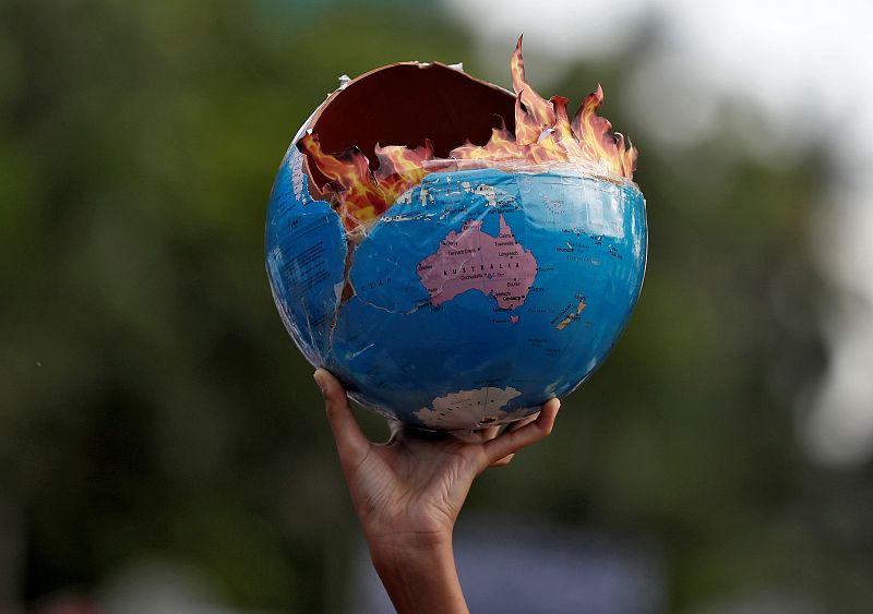 Un manifestante sostiene un globo terráqueo en llamas para representar como la falta de políticas comprometidas con el medio ambiente puede acabar con el planeta. En Mumbai, India.