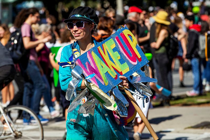 Una mujer acude a la marcha celebrada en la ciudad canadiense de Toronto con un cartel en el que se lee: "Despierta"