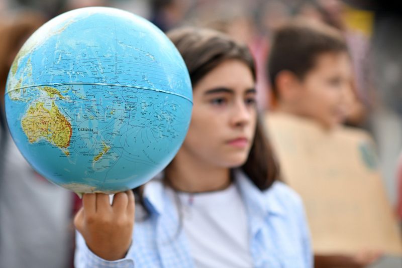 Una joven porta un globo terráqueo en la marcha por el clima que ha tenido lugar en Braga