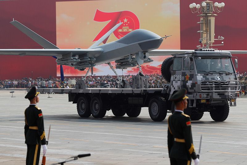 Un vehículo portando un avión militar participa en el desfile conmemorativo, el mayor de la historia de China.