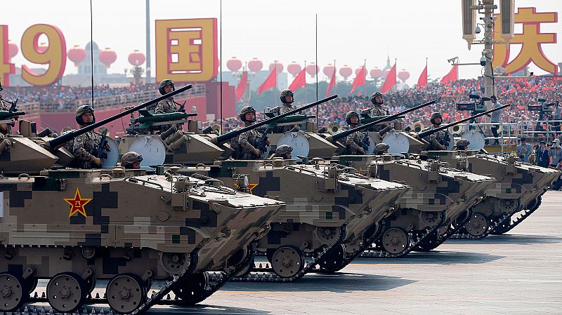 Soldados chinos a bordo de vehículos militares cruzan la plaza de Tiananmen de Pekín.