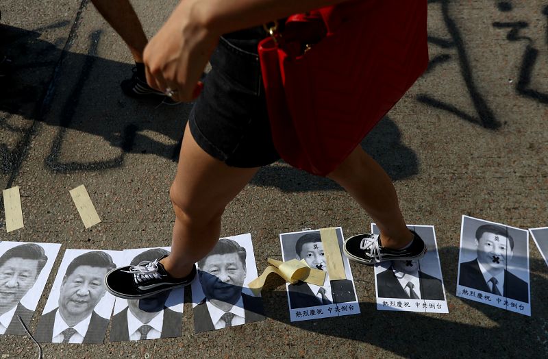 Un manifestante antigubernamental pisa fotos del presidente chino Xi Jinping en el distrito de Sham Shui Po