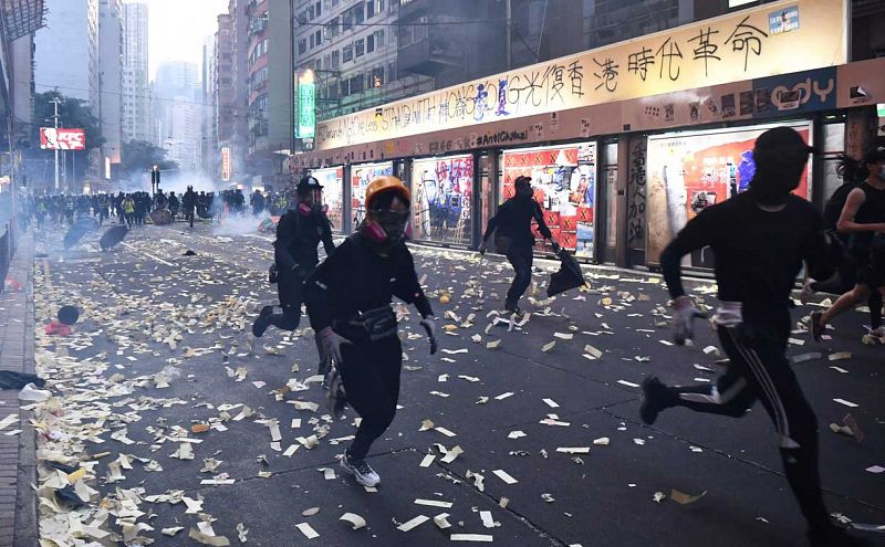 Manifestantes huyen de la policía durante enfrentamientos en el distrito de Wanchai en Hong Kong