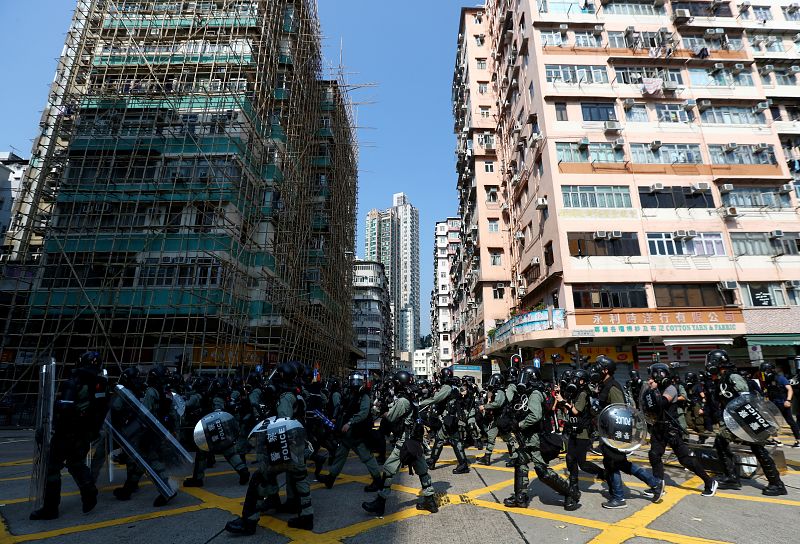Agentes de la policía antidisturbios marchan en el distrito de Sham Shui Po, en el Día Nacional de China en Hong Kong,